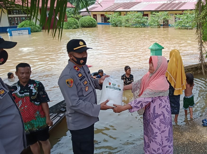 Kapolsek Pemayung IPTU Dwiyatno menyerahkan sembako bagi keluarga korban banjir di Pemayung, Batanghari.